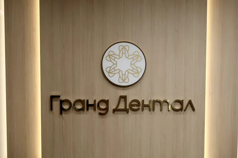 Стена с логотипом «Гранд Дентал» на ресепшне